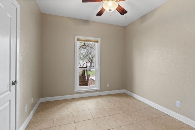 empty room with light tile patterned flooring, a ceiling fan, and baseboards