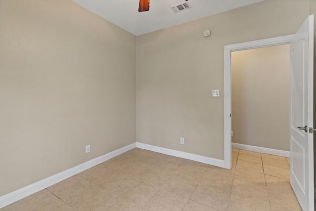 unfurnished room featuring light tile patterned floors, a ceiling fan, visible vents, and baseboards