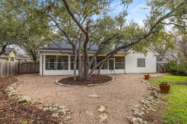 rear view of house featuring a sunroom and a fenced backyard