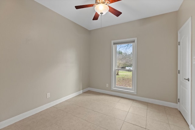 empty room with ceiling fan, baseboards, and light tile patterned floors