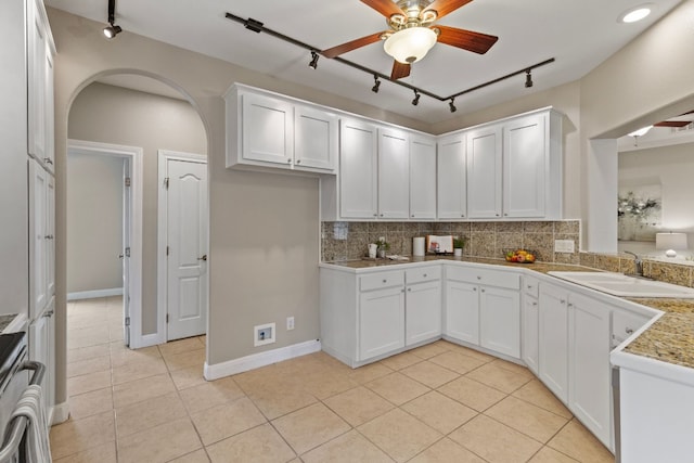 kitchen featuring light countertops, a sink, white cabinetry, and decorative backsplash