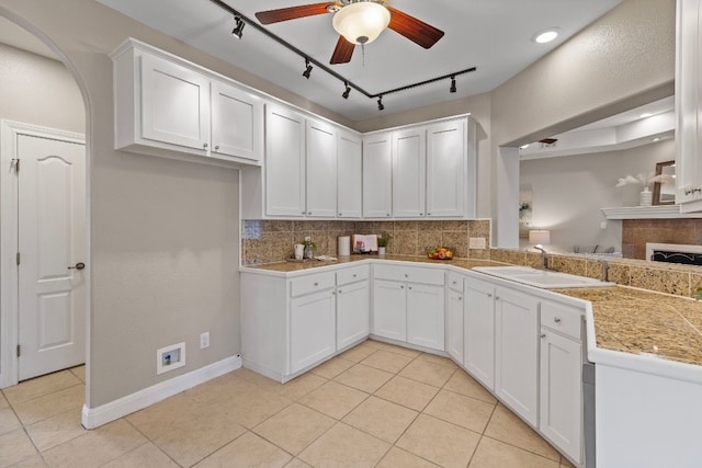 kitchen featuring tile counters, white cabinets, a sink, and decorative backsplash