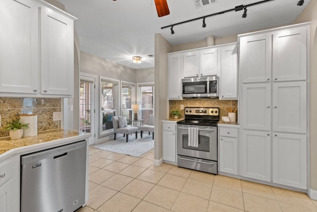 kitchen featuring white cabinetry, appliances with stainless steel finishes, tasteful backsplash, and light tile patterned flooring