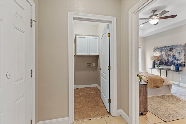 hallway featuring light tile patterned flooring and baseboards