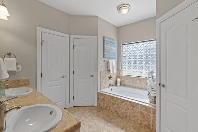 full bathroom featuring a closet, a sink, a bath, and tile patterned floors