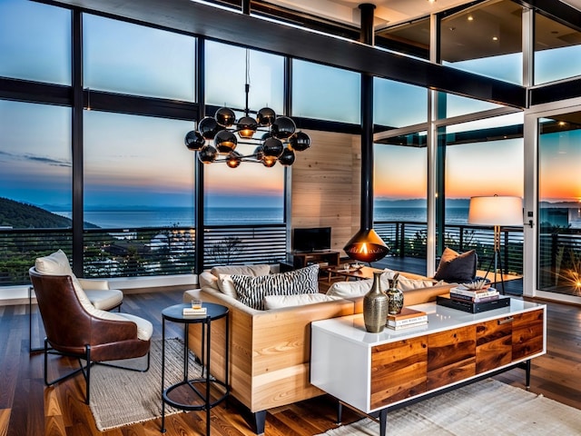 living room with floor to ceiling windows, wood finished floors, and a notable chandelier