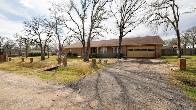 single story home featuring driveway, brick siding, an attached garage, and fence