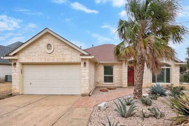 single story home featuring a shingled roof, a garage, cooling unit, stone siding, and driveway