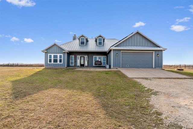 view of front facade with driveway, an attached garage, metal roof, and board and batten siding