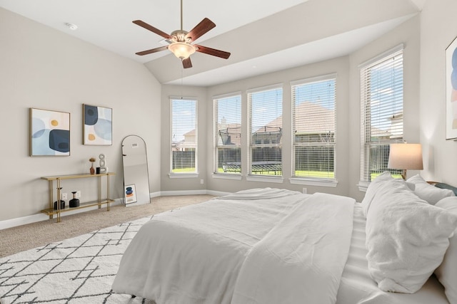 bedroom with light colored carpet, vaulted ceiling, baseboards, and multiple windows