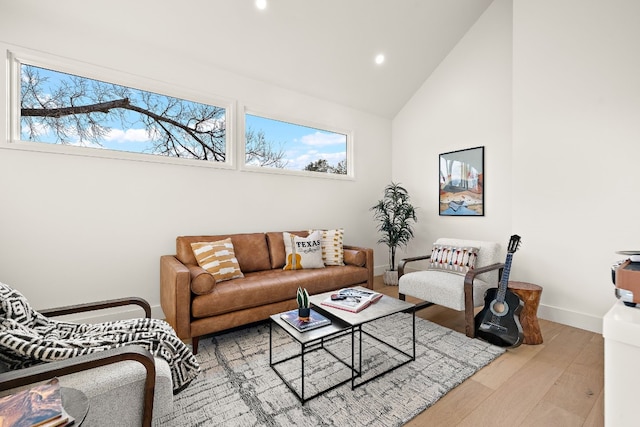 living area with recessed lighting, baseboards, a healthy amount of sunlight, and light wood finished floors