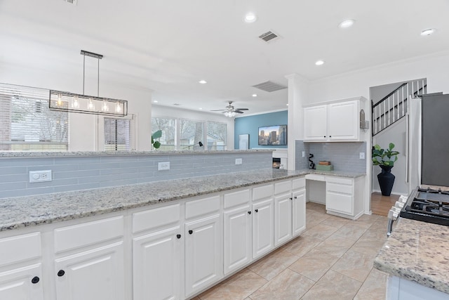 kitchen with visible vents, white cabinetry, hanging light fixtures, backsplash, and range with gas cooktop