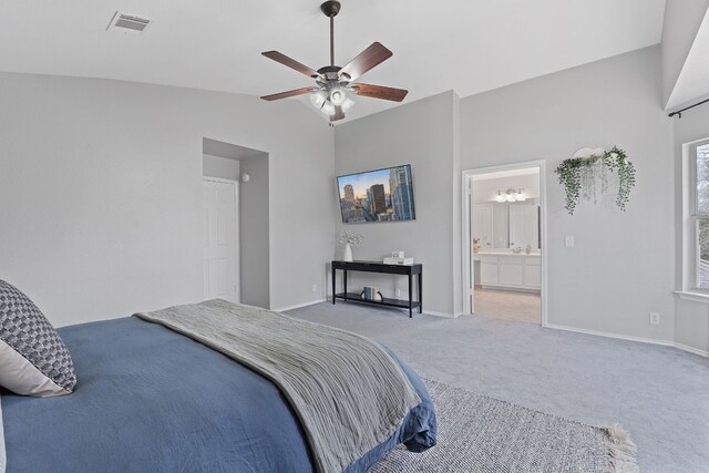 carpeted bedroom featuring lofted ceiling, ceiling fan, connected bathroom, visible vents, and baseboards