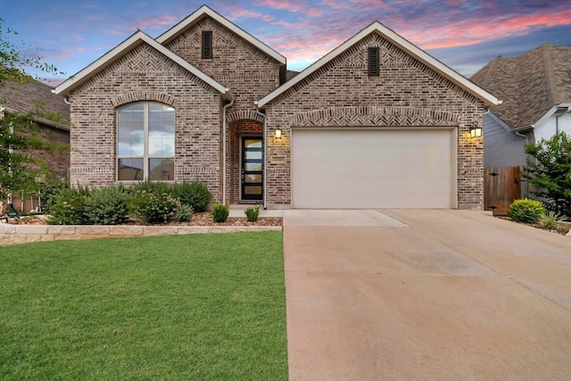 view of front of house featuring concrete driveway, brick siding, a front yard, and a garage