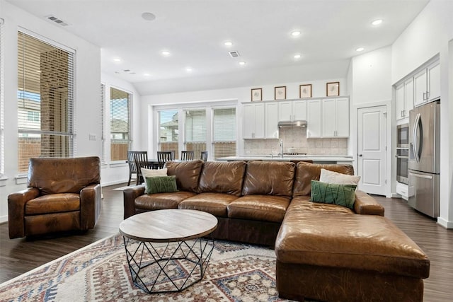 living area with baseboards, visible vents, recessed lighting, and dark wood finished floors