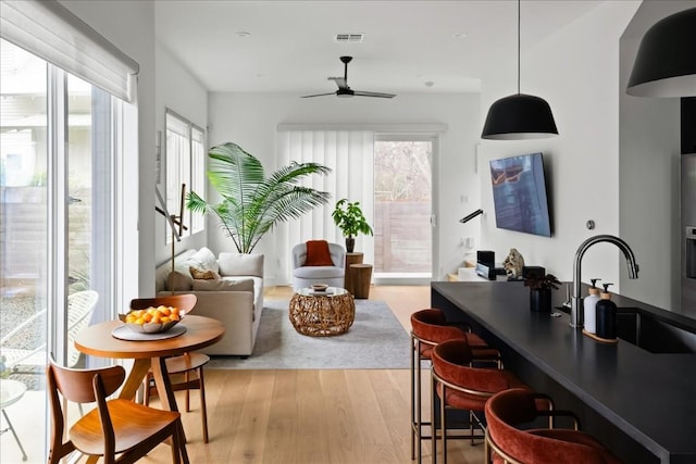 interior space featuring a sink, a ceiling fan, visible vents, and a wealth of natural light