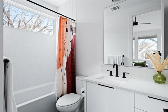 full bathroom with visible vents, vanity, shower / bath combo with shower curtain, and a wealth of natural light