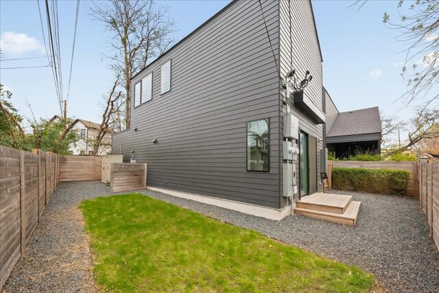 view of side of home featuring a fenced backyard and a yard