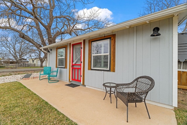 entrance to property featuring fence and a patio