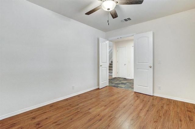 unfurnished bedroom with a ceiling fan, light wood-type flooring, visible vents, and baseboards