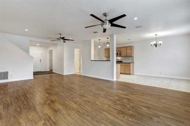 5006 Daymon Ct, Hutto, TX 78634 - unfurnished living room with a chandelier, light wood finished floors, ceiling fan, and recessed lighting