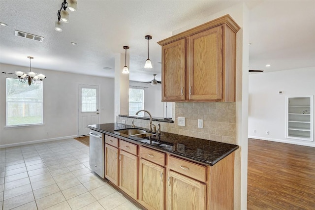 5006 Daymon Ct, Hutto, TX 78634 - kitchen with dishwasher, tasteful backsplash, hanging light fixtures, and dark stone countertops