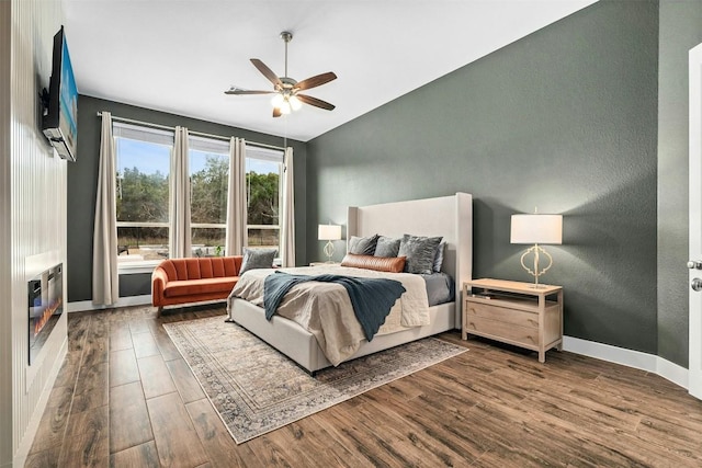 bedroom featuring vaulted ceiling, wood finished floors, a ceiling fan, and baseboards