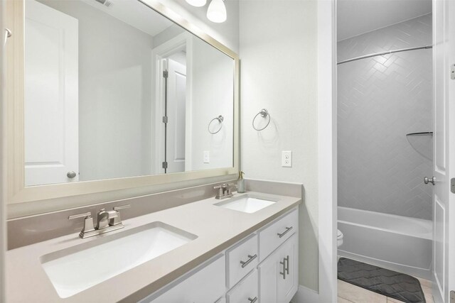 full bathroom featuring toilet, double vanity, a sink, and shower / bathing tub combination