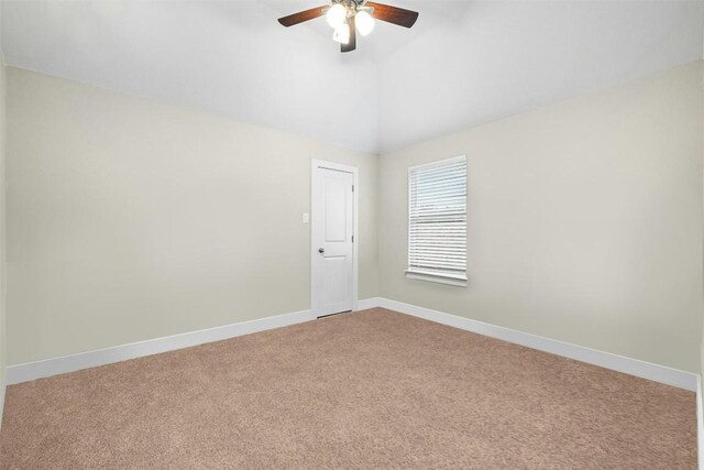 carpeted empty room featuring a ceiling fan, lofted ceiling, and baseboards