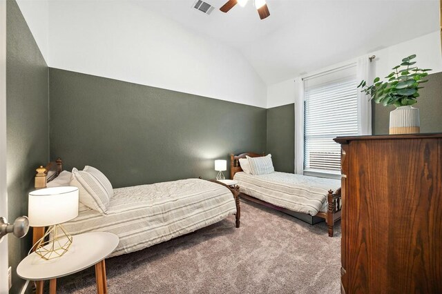 bedroom with vaulted ceiling, carpet flooring, visible vents, and a ceiling fan