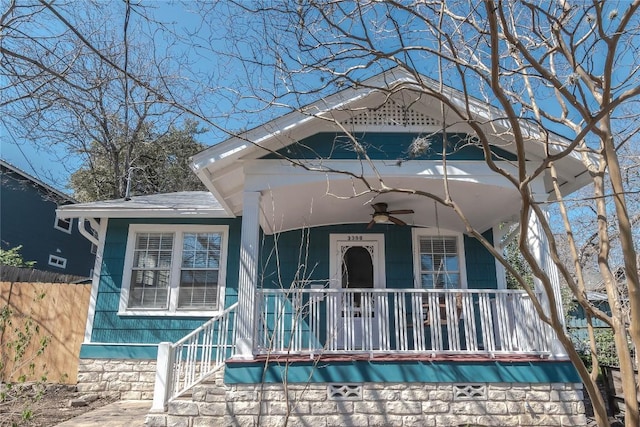 view of front of house featuring covered porch, ceiling fan, fence, and a shingled roof