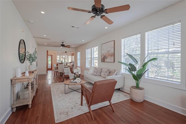 living area featuring baseboards, wood finished floors, visible vents, and recessed lighting