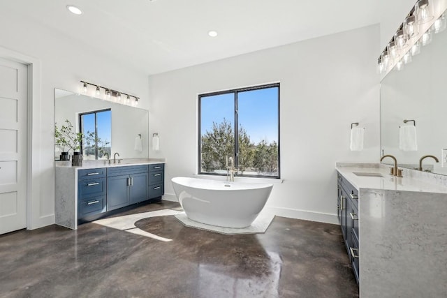 138 Cloudwood Ranch Rd, Briggs, TX 78608 - bathroom featuring finished concrete floors, two vanities, a soaking tub, and recessed lighting