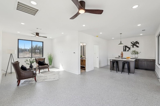 living room featuring baseboards, visible vents, light speckled floor, and recessed lighting