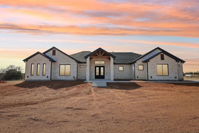 138 Cloudwood Ranch Rd, Briggs, TX 78608 - modern farmhouse style home with french doors, stone siding, and a shingled roof