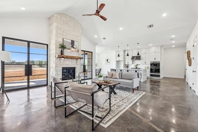 living area with a fireplace, visible vents, high vaulted ceiling, concrete floors, and baseboards