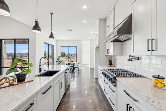 kitchen featuring under cabinet range hood, stainless steel appliances, a sink, white cabinetry, and pendant lighting