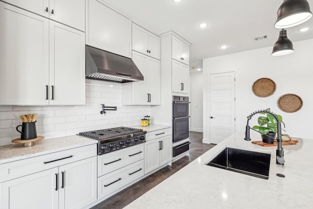 kitchen featuring a sink, visible vents, exhaust hood, white cabinetry, and stainless steel gas stovetop