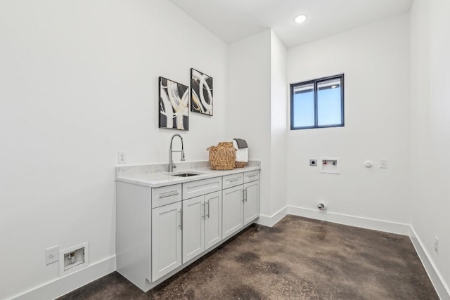 clothes washing area featuring cabinet space, baseboards, gas dryer hookup, hookup for an electric dryer, and a sink