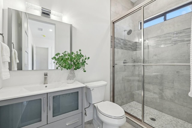 bathroom featuring visible vents, a tile shower, vanity, and toilet