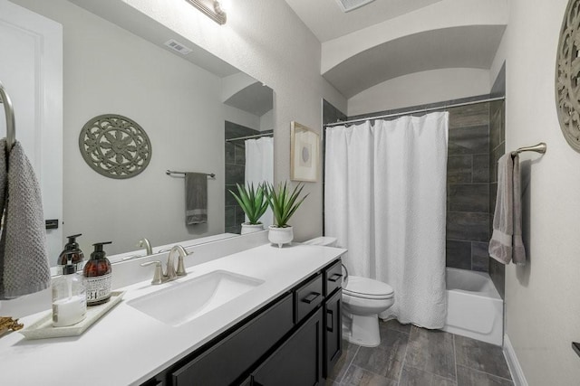 full bathroom featuring baseboards, visible vents, toilet, shower / bath combo with shower curtain, and vanity