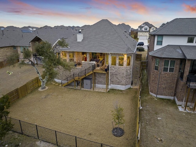 back of house featuring a residential view, a fenced backyard, and a chimney