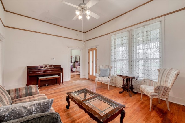 living area featuring ceiling fan, ornamental molding, and wood finished floors