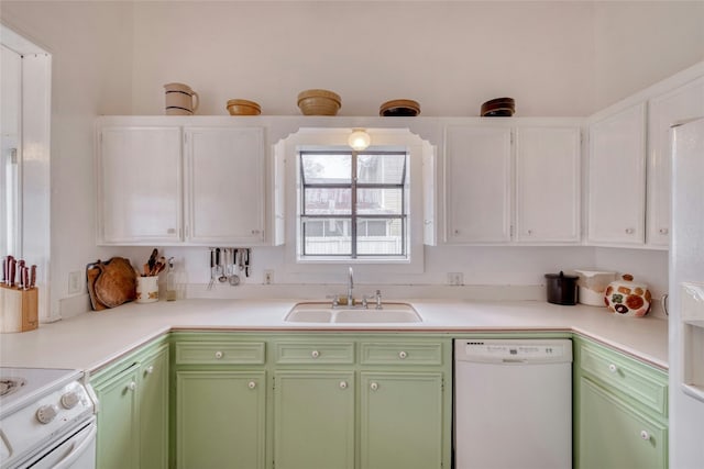 kitchen featuring light countertops, green cabinets, white cabinets, a sink, and white appliances