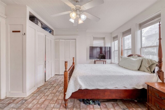 bedroom with ceiling fan and brick floor