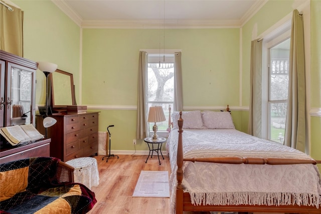 bedroom with light wood-style floors, baseboards, ornamental molding, and french doors