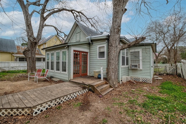 back of property with cooling unit, fence, and a wooden deck
