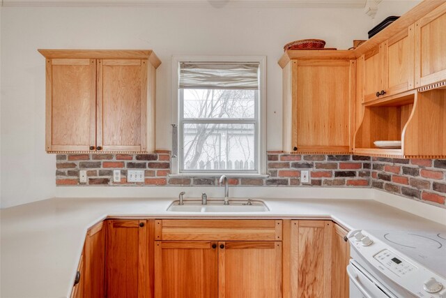 kitchen with white range with electric cooktop, light countertops, a sink, and light brown cabinetry