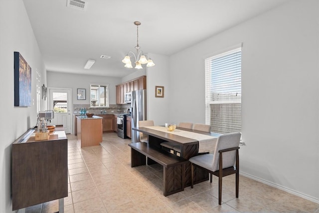 dining space with light tile patterned floors, baseboards, visible vents, and a notable chandelier