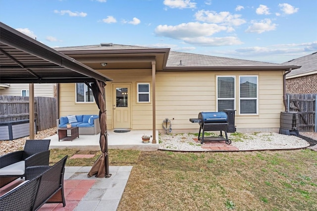 back of property featuring an outdoor hangout area, a patio, a lawn, and fence